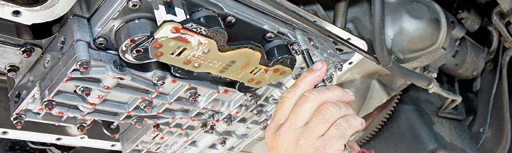a mechanic taking off a car part
